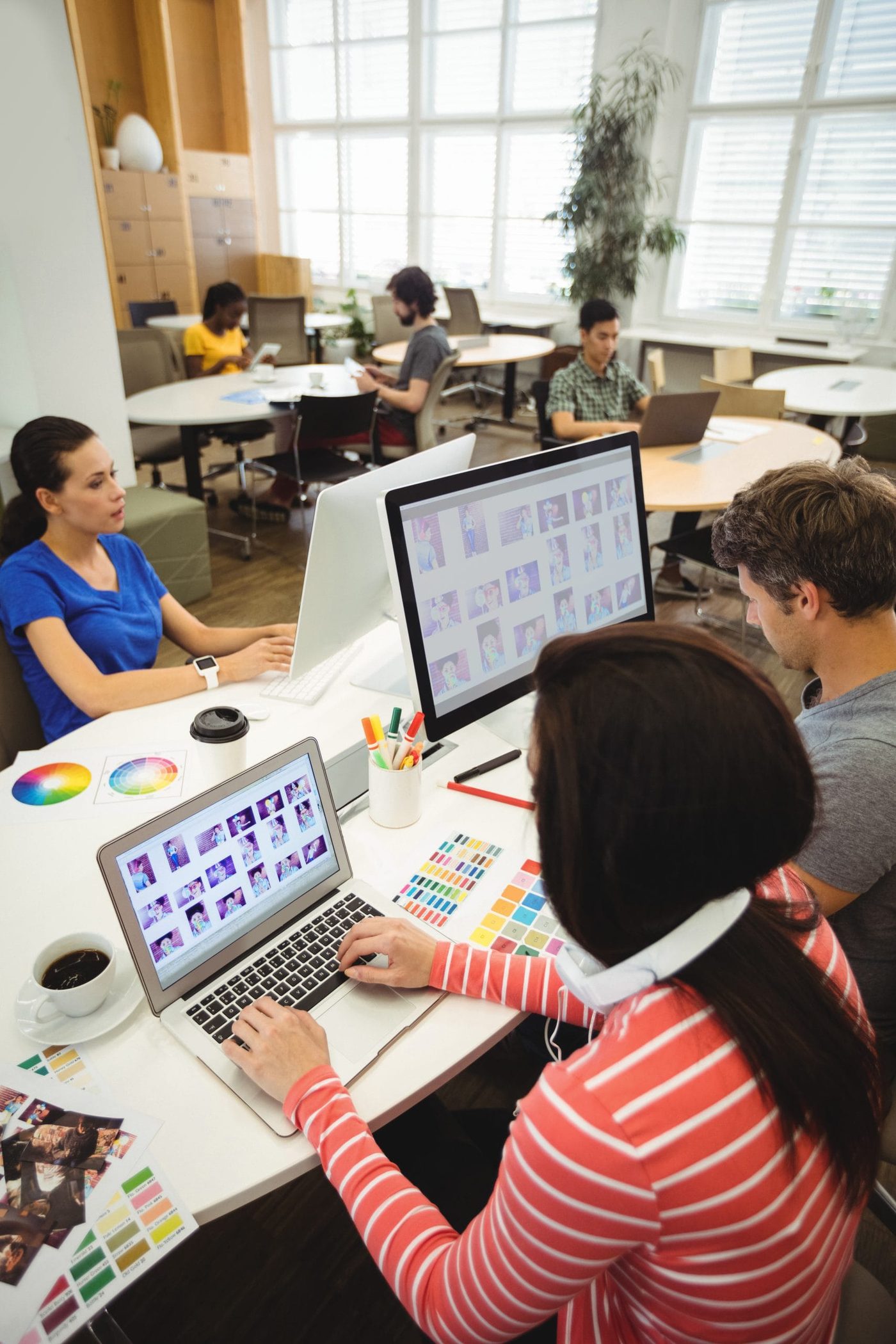 - in-office - graphic designers working at their desk scaled - ui/ux